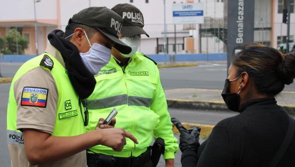 Policías advierten a venderos ambulantes que deben volver a sus domicilios, como parte de las medidas que prohíben a la población estar en las calles, este viernes en una céntrica calle de Quito (Ecuador). (Foto: EFE).
