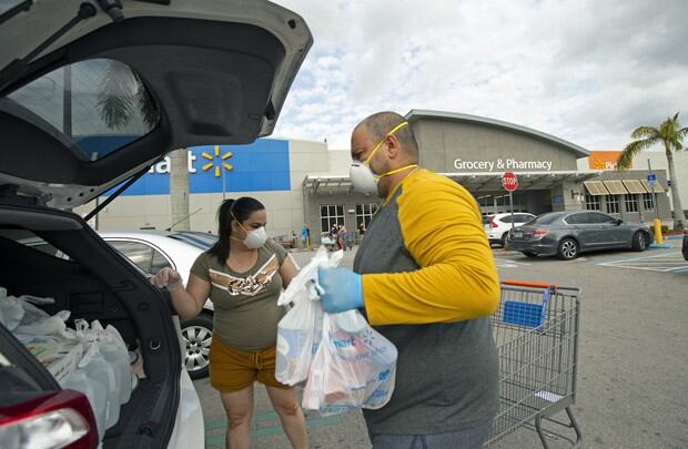Coronavirus Estados Unidos | Miami | Una pareja de esposos coloca sus bolsas luego de realizar compras en un supermercado de Miami. Foto: David Santiago/Miami Herald via AP