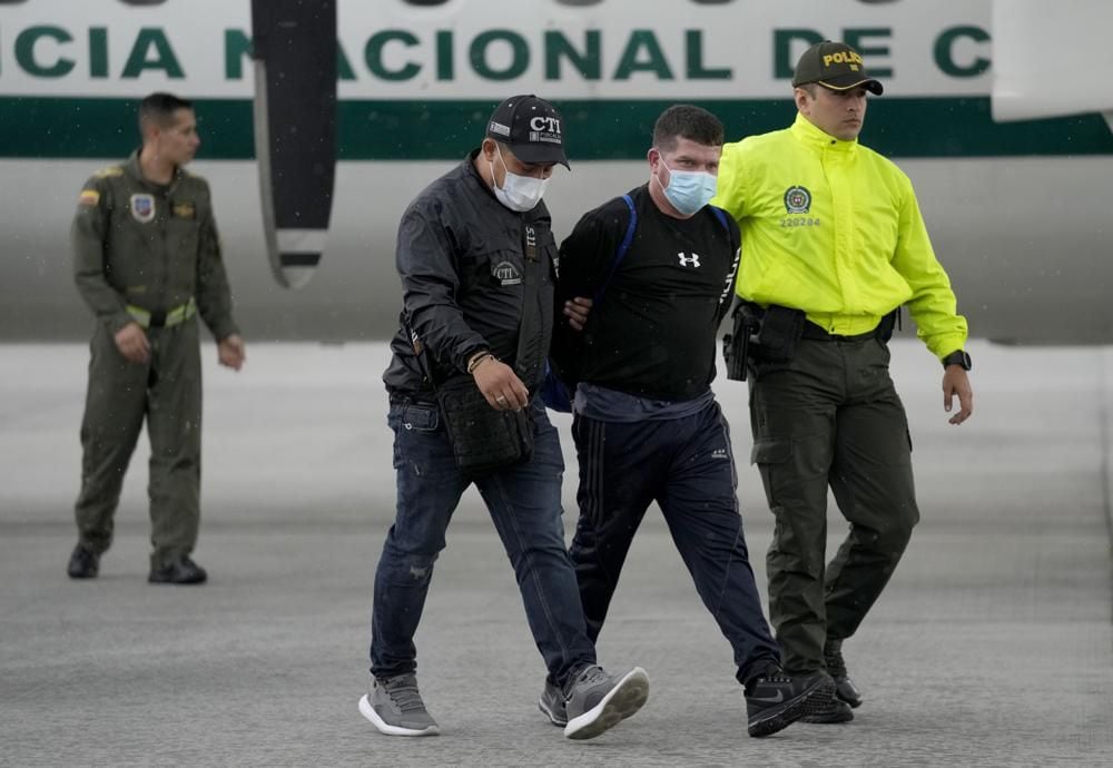 Francisco Luis Correa Galeano es escoltado por la policía después de desembarcar en un aeropuerto de Bogotá, Colombia, el miércoles 8 de junio de 2022. (AP Foto/Fernando Vergara).