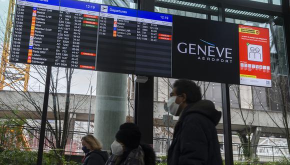 Hoy, en Suiza, pasajeros observan cómo se cancelan sus vuelos hacia Gran Bretaña, una de las medidas tomadas por su gobierno para evitar la propagación de la nueva cepa del coronavirus. EFE