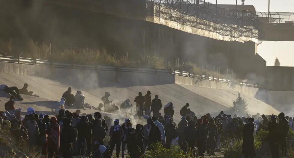 El humo sale de pequeñas fogatas que mantienen calientes a los migrantes mientras esperan para cruzar la frontera entre México y Estados Unidos desde Ciudad Juárez, el lunes 12 de diciembre de 2022. (Foto AP/Christian Chávez).