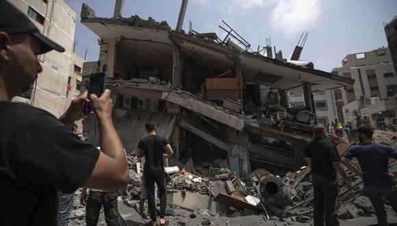 Los palestinos inspeccionan el edificio residencial dañado después de que fue alcanzado por ataques aéreos israelíes, en Gaza.