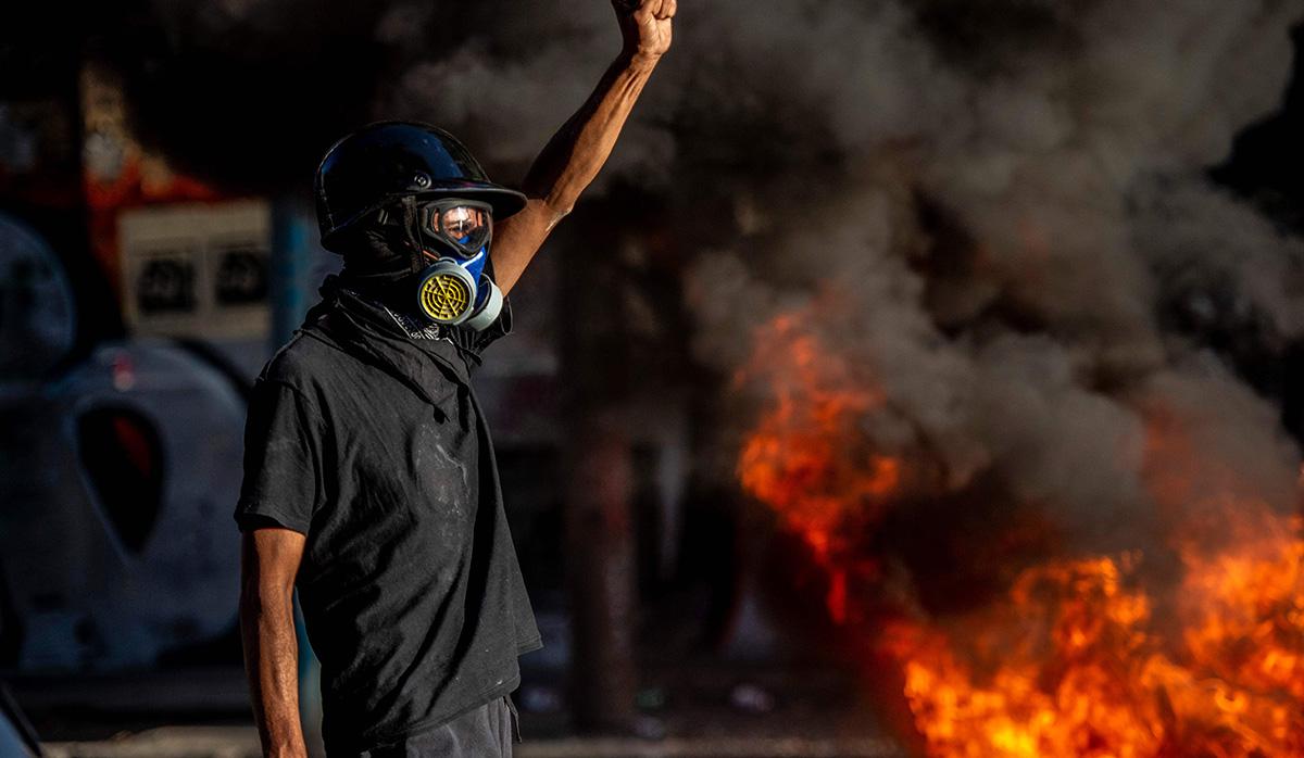 Una decena de encapuchados vandalizó además un autobús abandonado y lo colocó bloqueando una calle, mientras que paralelamente un grupo de estudiantes se manifestaba en Plaza Nuñoa. (Foto: AFP)