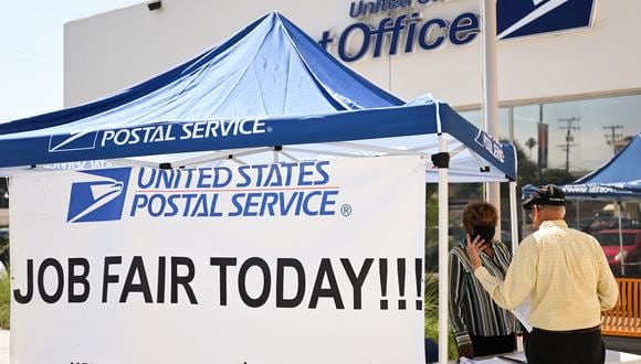 Una persona recibe información de empleo durante una feria de empleo contratando nuevos trabajadores postales y asistentes de cartero en una oficina de correos del Servicio Postal de los Estados Unidos (USPS) el 18 de julio de 2022 en Inglewood, California. (Foto de Patrick T. FALLON / AFP)