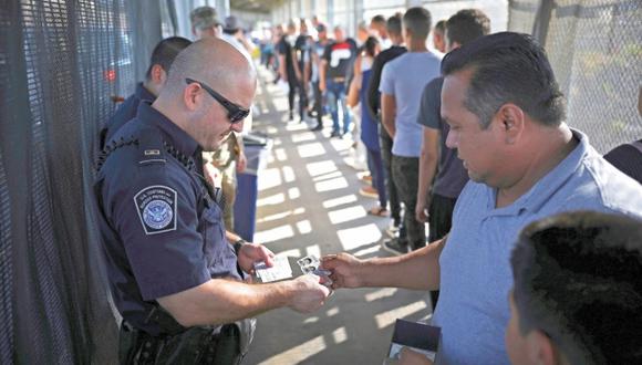 Un agente fronterizo verifica la visa de un hombre en el puente Puerta México. Foto: Archivo de AP
