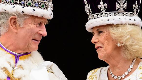 El rey Carlos III de Gran Bretaña mira a la reina Camilla mientras están en el balcón del Palacio de Buckingham, en Londres, después de su coronación, el 6 de mayo de 2023. (Foto de Leon Neal / POOL / AFP)