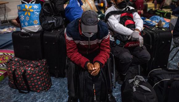 Un migrante con una máscara de protección es visto rodeado de equipajes en Santiago de Chile. (Foto referencial, Cristobal Olivares/Bloomberg).