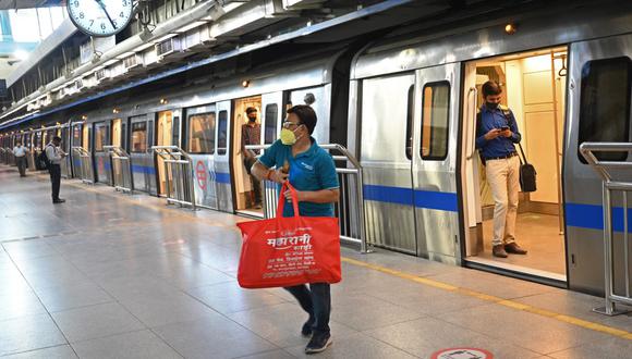 Los pasajeros usan el metro de Nueva Delhi después de que se permitiera que operara al 50 por ciento de su capacidad. (Foto de Money SHARMA / AFP).