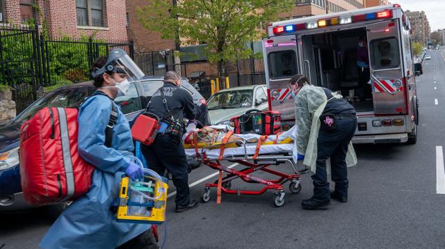 Los bomberos y paramédicos de la ciudad de Nueva York en equipos de protección ayudan a un paciente sospechoso de estar infectado con coronavirus en el Bronx, Nueva York, Estados Unidos. (Foto: David Dee Delgado/Getty Images/AFP).