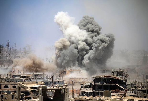 In this file photo taken on May 22, 2017, smoke rises from buildings following a reported airstrike in a rebel-held area in the southern Syrian city of Daraa. (Photo by Mohamad ABAZEED / AFP).