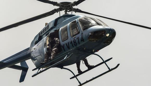 Un helicóptero de los cuerpos de seguridad de Venezuela sobrevuela la ciudad de Valencia en busca de militares rebeldes.