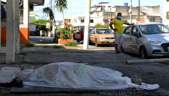 Un hombre mira el cuerpo de una persona que estuvo tres días fuera de una clínica en Guayaquil, el epicentro del coronavirus en Ecuador. (AFP / Pin de Marcos / Str).