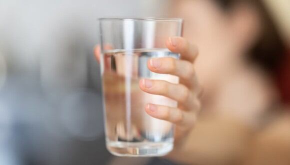 Una mujer sosteniendo un vaso de agua. | Imagen referencial: Unsplash
