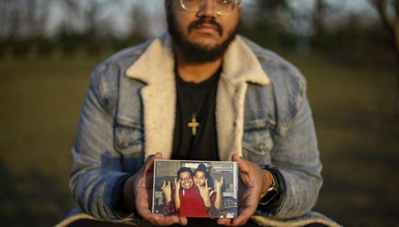 Adam Almonte muestra una foto en la que se ve con su hermano mayor, Fernando Morales, el 16 de marzo del 2022 en un parque de Nueva York. Fernando murió por el COVID-19 en abril del 2020. (AP Photo/David Goldman).