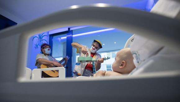 Imagen referencial. Payasos de la ONG Sonrisa Medica (Medical Smile) actúan para un bebé en el ala infantil de un hospital en España. (JAIME REINA / AFP).