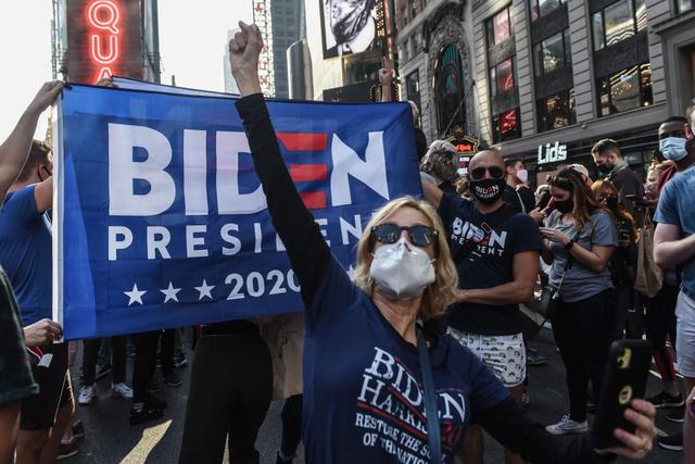 La gente celebra en Times Square, Nueva York después de que se anunció que el candidato demócrata Joe Biden sería el próximo presidente de los Estados Unidos. (Stephanie Keith/Getty Images/AFP).