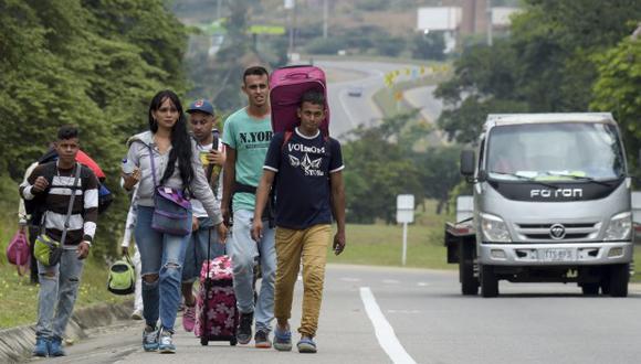 Foto referencial que muestra a migrantes caminando al costado de la carretera. (Foto referencial: AFP)