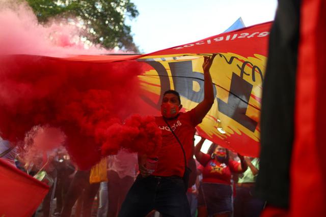 Un hombre suelta humo de colores, mientras participa en una protesta que pide el juicio político al presidente de Brasil, Jair Bolsonaro, y contra su manejo de la pandemia de la enfermedad del coronavirus (COVID-19), en Río de Janeiro, Brasil, el 3 de julio de 2021. (REUTERS/Pilar Olivares).