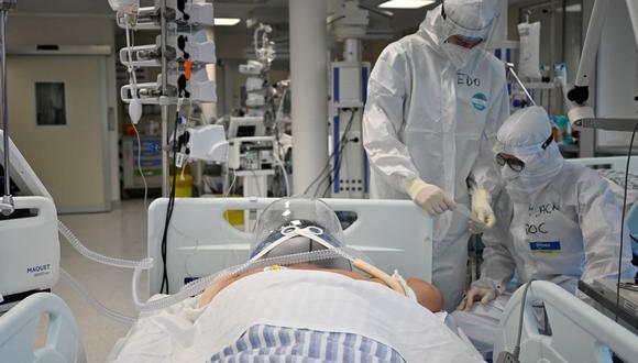 Personal médico está cerca de un paciente que utiliza una nueva tecnología no invasiva que puede reducir la necesidad de intubación en la unidad de cuidados intensivos (UCI) de coronavirus covid-19 en el Instituto de Cardiología Clínica (ICC) en Roma, el 30 de diciembre de 2021. (Alberto PIZZOLI / AFP).