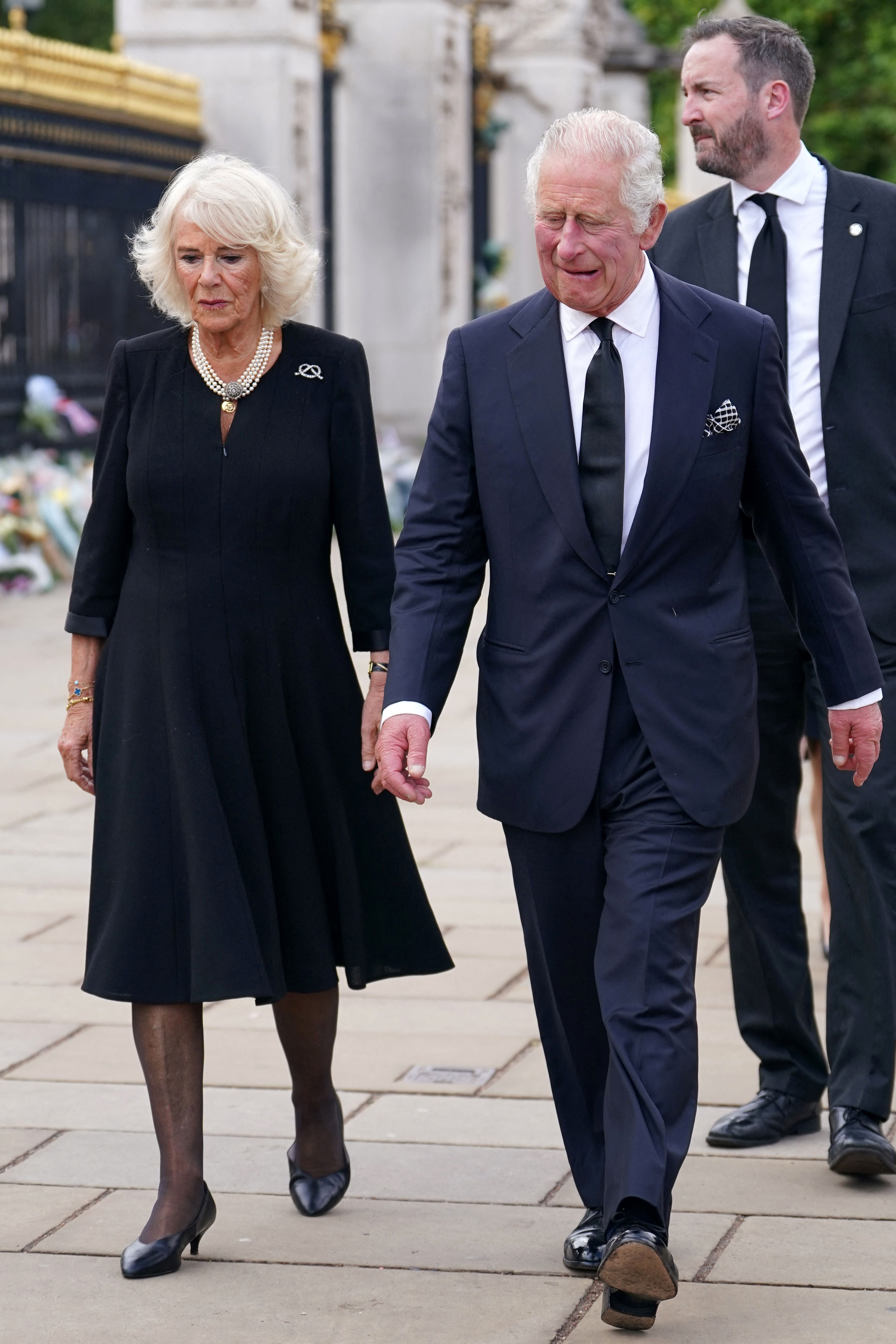 Britain's King Charles III and Britain's Queen Consort Camilla wave to the crowd upon their arrival at Buckingham Palace in London, on September 9, 2022, one day after Queen Elizabeth II died at the age of 96 years.