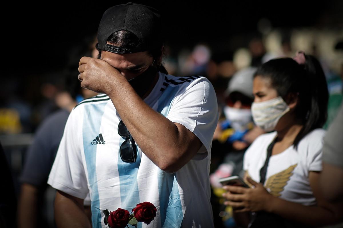 Seguidores de Diego Armando Maradona son vistos conmovidos en los exteriores de la Casa Rosada en Buenos Aires, Argentina. (EFE/Juan Ignacio Roncoroni).