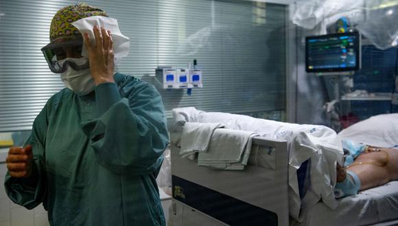 Una trabajadora sanitaria se limpia las gafas mientras atiende a un paciente de coronavirus en la Unidad de Cuidados Intensivos (UCI) del Hospital del Mar en Barcelona, España, el 4 de agosto de 2021. (JOSEP LAGO / AFP).