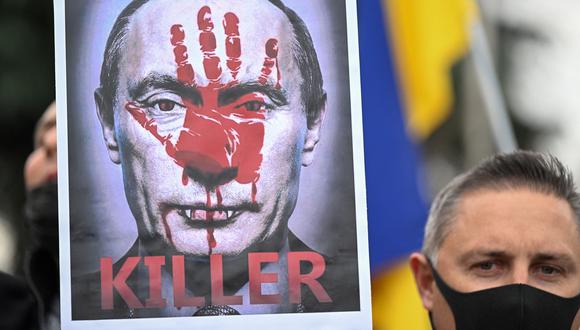 Un manifestante sostiene un cartel que representa al presidente ruso Vladimir Putin y que dice "Asesino" durante una protesta contra la invasión rusa de Ucrania, en Madrid el 27 de febrero de 2022. (Foto de GABRIEL BOUYS / AFP).