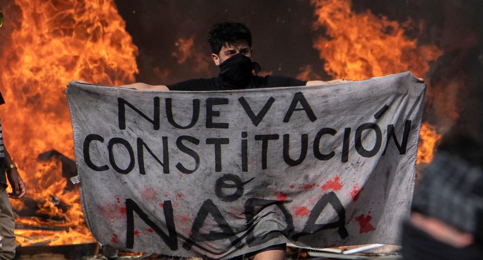 Un manifestante sostiene un trozo de tela que dice "Nueva Constitución o Nada" durante una manifestación en la Plaza Italia en Santiago. (AFP/Referencial).