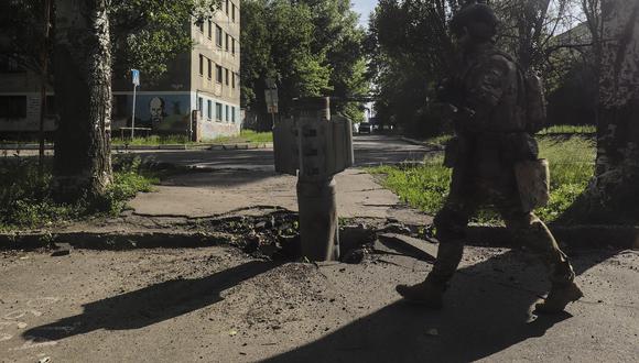 Un soldado ucraniano pasa junto a una parte de un cohete cerca de la línea del frente en la ciudad de Severodonetsk, región de Lugansk, Ucrania. (Foto: EFE)