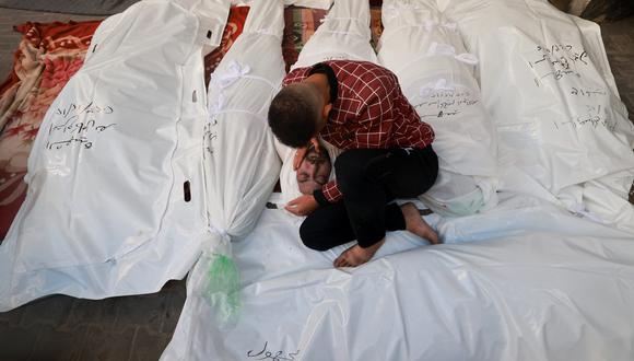 Un joven llora junto a los cuerpos de familiares asesinados tras el bombardeo israelí en el hospital al-Najjar en Rafah, en el sur de la Franja de Gaza, el 12 de diciembre de 2023, en medio de batallas en curso entre Israel y el grupo militante palestino Hamás. (Foto de MOHAMMED ABED / AFP)