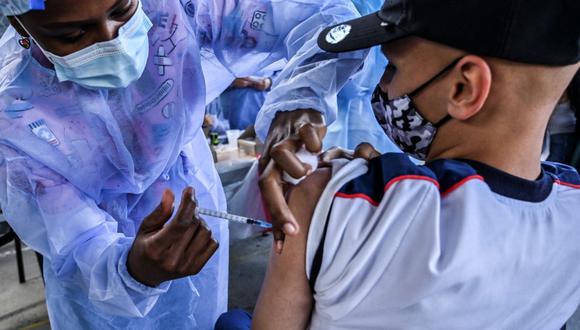 Un niño es inoculado con la vacuna Pfizer-BioNtech COVID-19 en una escuela en Medellín, Colombia, el 7 de septiembre de 2021. (Joaquín SARMIENTO / AFP).