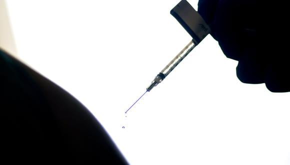 Imagen referencial en donde se ve a contraluz la inyección de una dosis de la vacuna contra el coronavirus. AP
