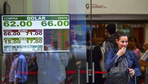 El tipo de cambio oficial se cotizaba a 76,17/76,18 pesos; mientras que el "dólar blue" se mantenía estable en 146 pesos. (Foto: AFP)