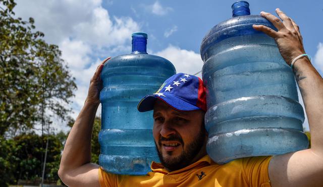 En Caracas, numerosos venezolanos hacen largas filas desde hace varios días para recoger agua de pequeños manantiales que fluyen de El Ávila, una cadena montañosa que bordea la capital de Venezuela. (AFP).