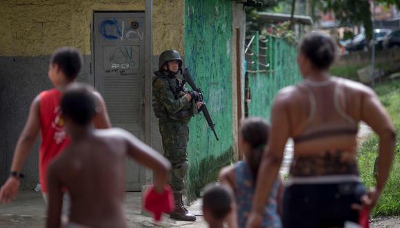 Imagen referencial. Una familia camina cerca de un soldado del ejército brasileño que patrulla en Río de Janeiro, Brasil, el 7 de febrero de 2018. (AFP / MAURO PIMENTEL).