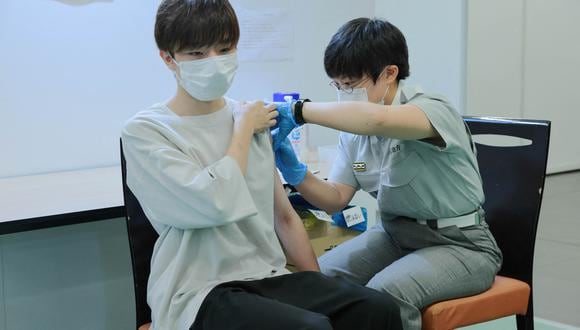Un miembro de la brigada de bomberos de Tokio coloca una dosis de la vacuna contra el Covid-19 en la Universidad de Aoyama, el 2 de agosto de 2021. Foto: Stanislav Kogiku / PISCINA / AFP