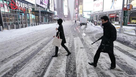 La gente cruza la calle en Times Square el pasado 17 de diciembre de 2020 en Nueva York, la mañana después de que una poderosa tormenta de invierno azotara los estados del noreste de Estados Unidos. (TIMOTHY A. CLARY / AFP).