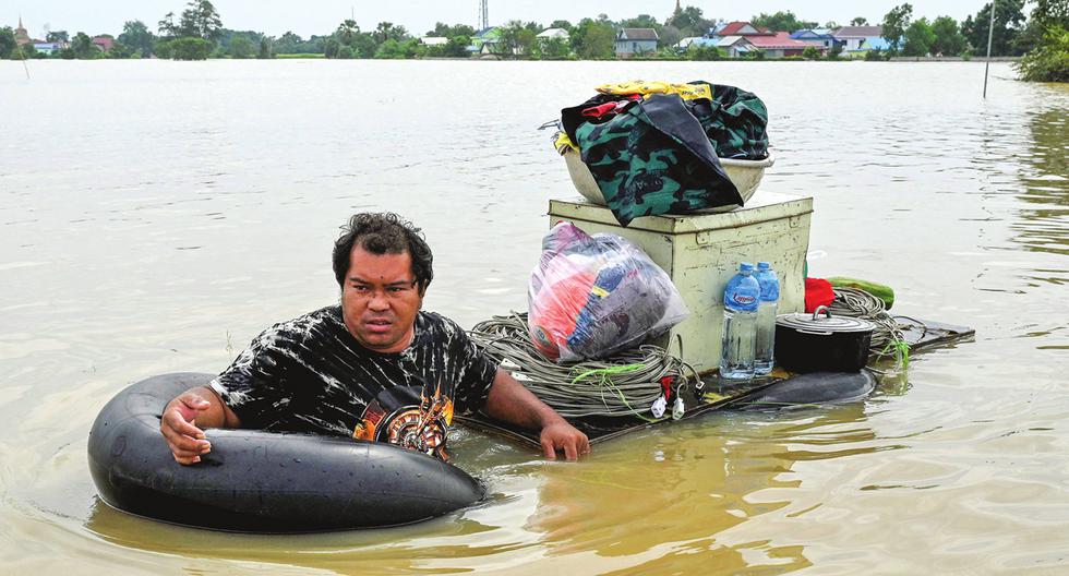 Un hombre transporta mercancías a través de las aguas de la inundación en las afueras de Phnom Penh, Camboya, tras las fuertes lluvias monzónicas. Asia es una de las regiones que se vería más afectada por los desplazamientos climáticos en el 2050. (Foto: AFP)