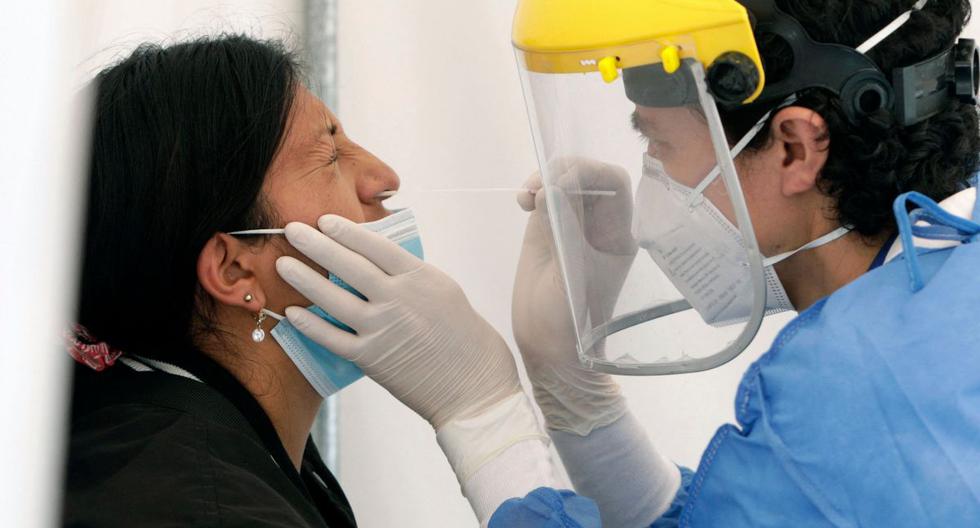 En la imagen, una trabajadora de la salud toma una muestra nasal de Covid-19 de una mujer para una prueba de PCR. (Foto de archivo: Cristina Vega/ RHOR/AFP)