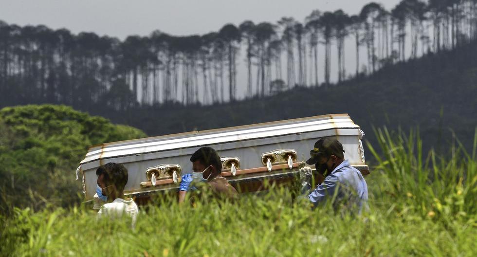Familiares llevan el ataúd de una presunta víctima del nuevo coronavirus en el cementerio Parque Memorial Jardín de los Ángeles, a 14 km al norte de Tegucigalpa. (Foto por ORLANDO SIERRA / AFP).