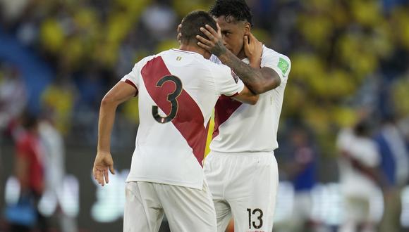 Renato Tapia y Aldo Corzo se felicitan en el partido contra Colombia en Barranquilla. (AP Photo/Fernando Vergara)
