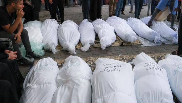 Un familiar palestino espera con otros para recoger los cuerpos envueltos en sudarios funerarios con sus nombres escritos para su identificación, en un hospital de Rafah tras los ataques de Israel. (Foto de SAID KHATIB / AFP).
