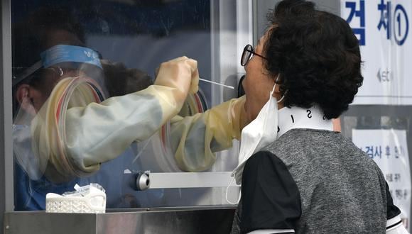 Un médico toma muestra a una persona para una prueba de COVID-19. (Foto: Jung Yeon-je / AFP)
