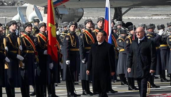 El presidente de China, Xi Jinping, acompañado por el viceprimer ministro ruso, Dmitry Chernyshenko, pasa junto a los guardias de honor durante una ceremonia de bienvenida en el aeropuerto Vnukovo de Moscú el 20 de marzo de 2023. (Foto de Anatoliy Zhdanov / Kommersant Photo / AFP)