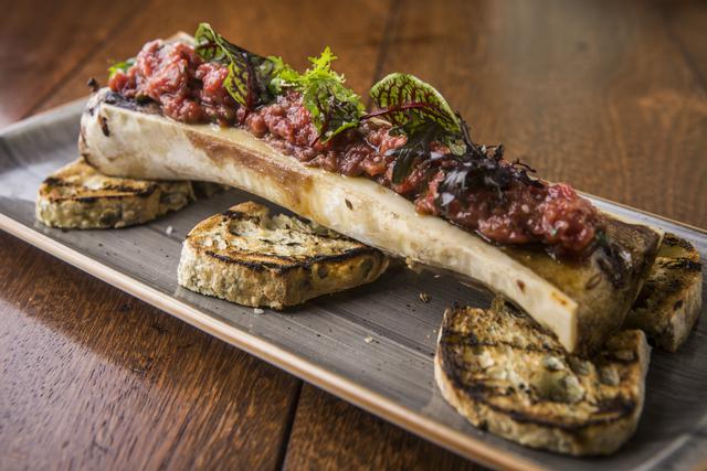 Steak tartare de lomo fino con huevo de corral confitado, sal de maras y cebolla china. Viene servido sobre tuétano a la parrilla.