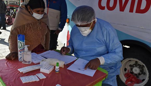 Una mujer registra su nombre para hacerse la prueba de la enfermedad del coronavirus en una unidad médica móvil de vacunación y pruebas en La Paz el 19 de julio de 2022. (Foto: Aizar RALDES / AFP)