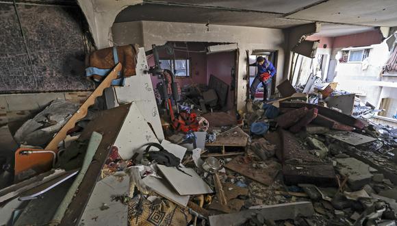 Imagen referencial. Un palestino busca sus pertenencias en medio de los escombros de un edificio impactado por el ataque aéreo enviado desde Israel. AFP