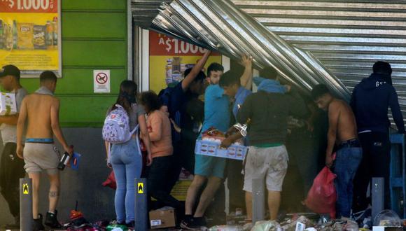 La gente saquea un supermercado en Puente Alto, área metropolitana de Santiago de Chile, el 20 de octubre. (Foto: AFP).