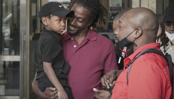 James Irons, centro, sostiene a su sobrino Michael, de 5 años, cuando sale de la Corte Suprema de Brooklyn luego de su exoneración, el viernes 15 de julio de 2022, en Nueva York. (Foto AP/Bebeto Matthews).