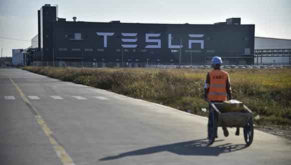 A worker walks on a road next to the new Tesla factory built in Shanghai on November 8, 2019. (Photo by HECTOR RETAMAL / AFP)